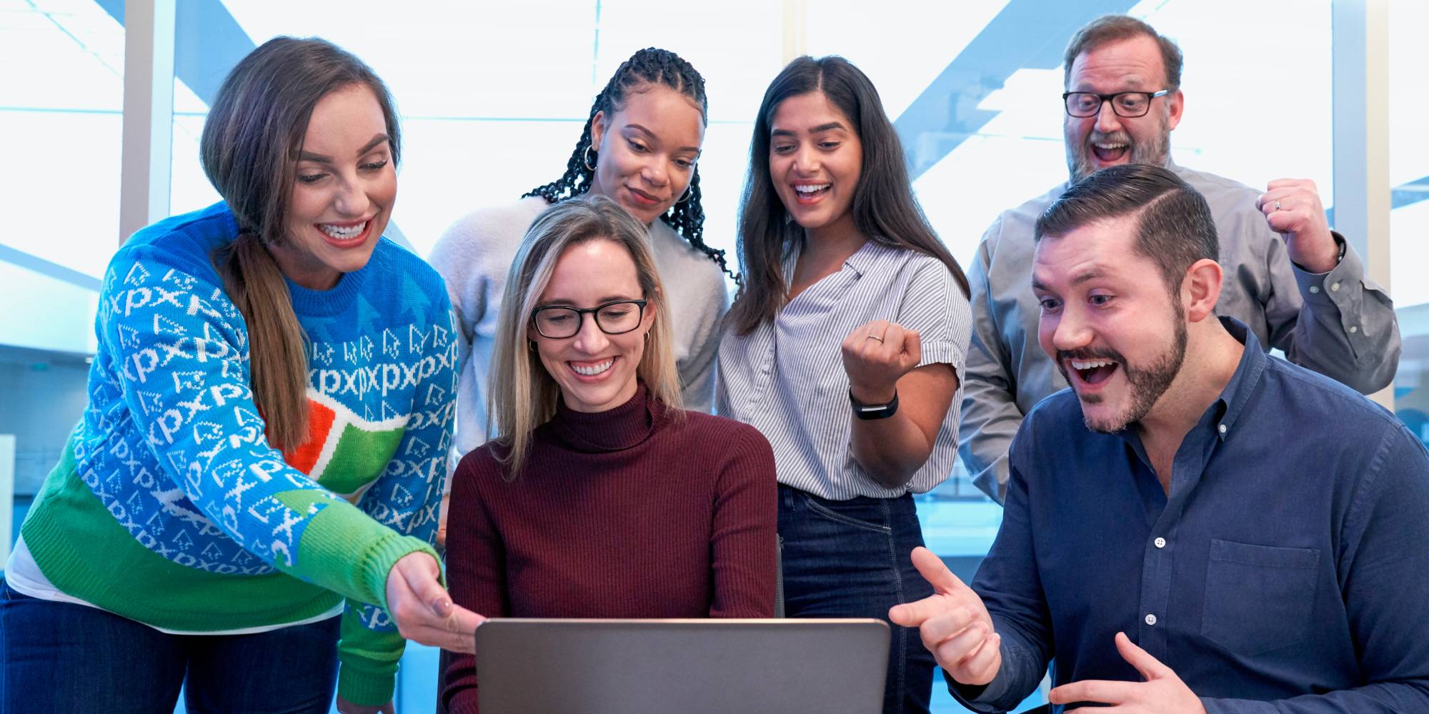 People celebrating in front of laptop