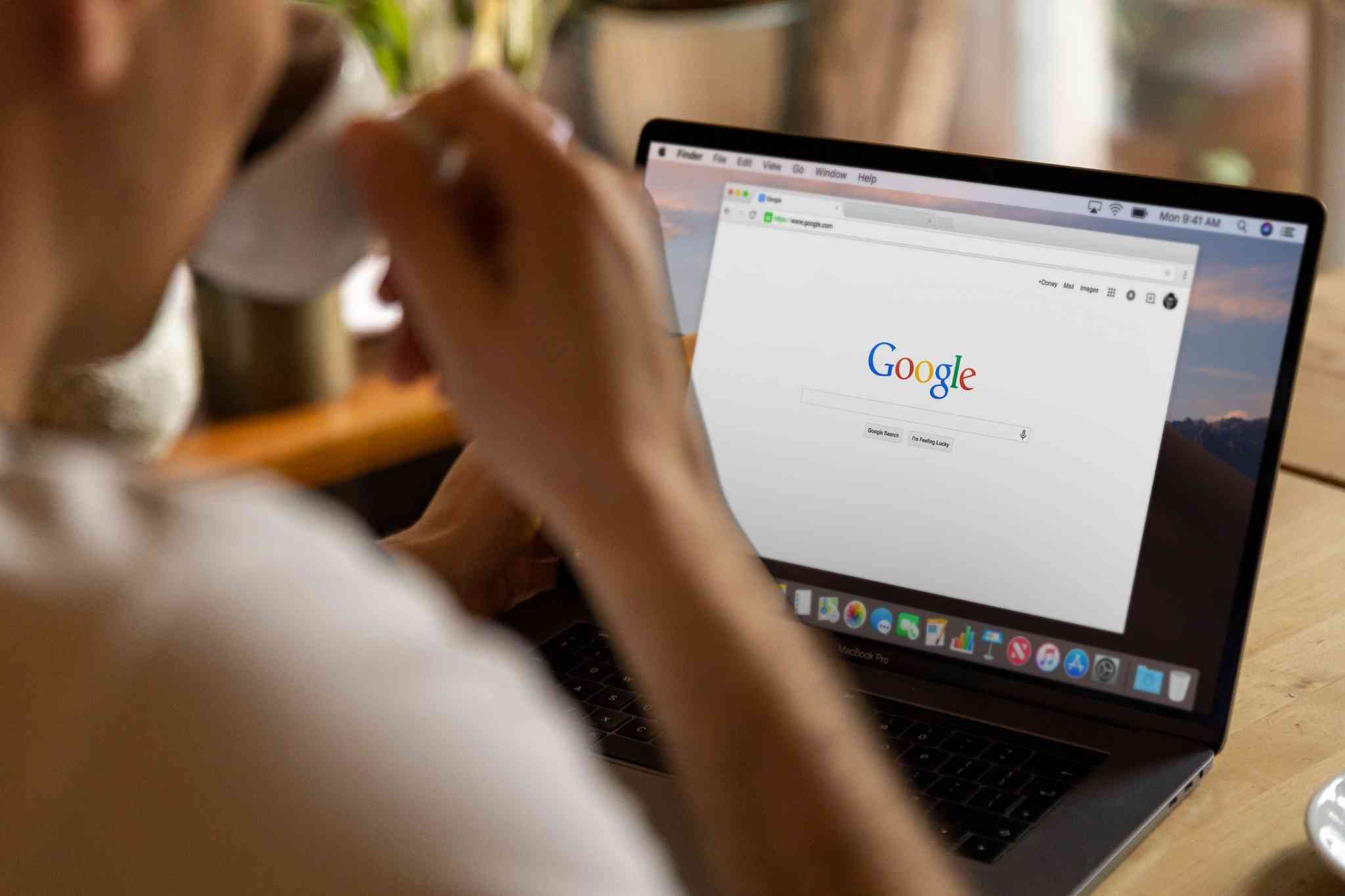 man drinking coffee while googling