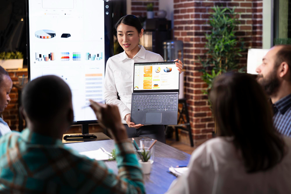 A woman gives a business presentation with a laptop.